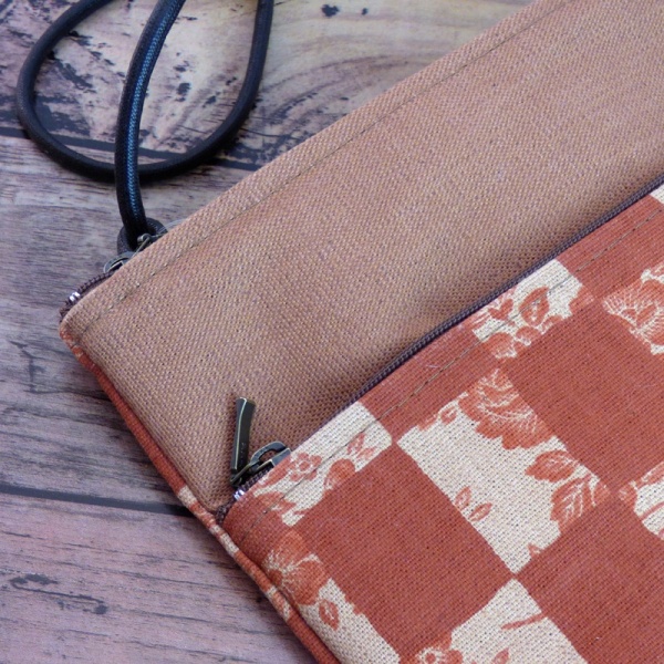Close up of canvas handbag in brick orange with a check design