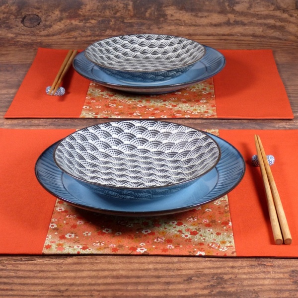 Two orange Flowers & Bells placemat on table with plates and chopsticks