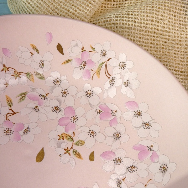 Close up of pink and gold sakura decoration on a pale pink Japanese plate