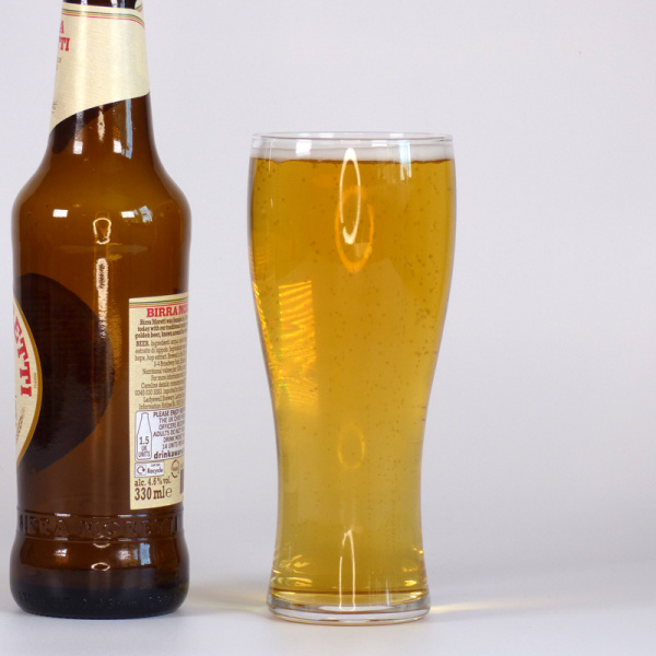 Slim Japanese beer glass next to beer bottle