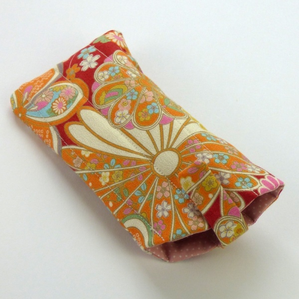 Sunglasses case in red traditional Japanese floral fabric showing closed fastening