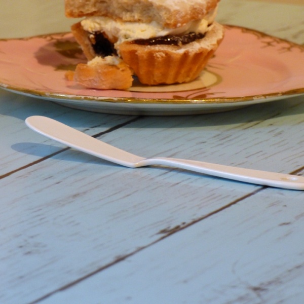 White enamel spreader with cupcake on kitchen top