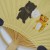 Close up of reverse side of fan showing a small bear and tiger sharing candy floss