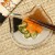 Calico cat small glass plate with Japanese pickles and chopsticks on table