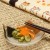 Calico cat small glass plate with Japanese pickles and chopsticks on table