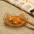 Ginger tabby cat small glass plate with Japanese pickles and chopsticks on table