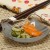 Grey tabby cat small glass plate with Japanese pickles and chopsticks on table