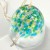 Close up of dappled green and blue design on glass wind chime