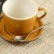 Japanese Tsuchime teaspoon next to caramel cup and saucer