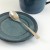 Japanese Tsuchime teaspoon on blue saucer.