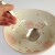 Japanese ramen spoon held in hand over large bowl